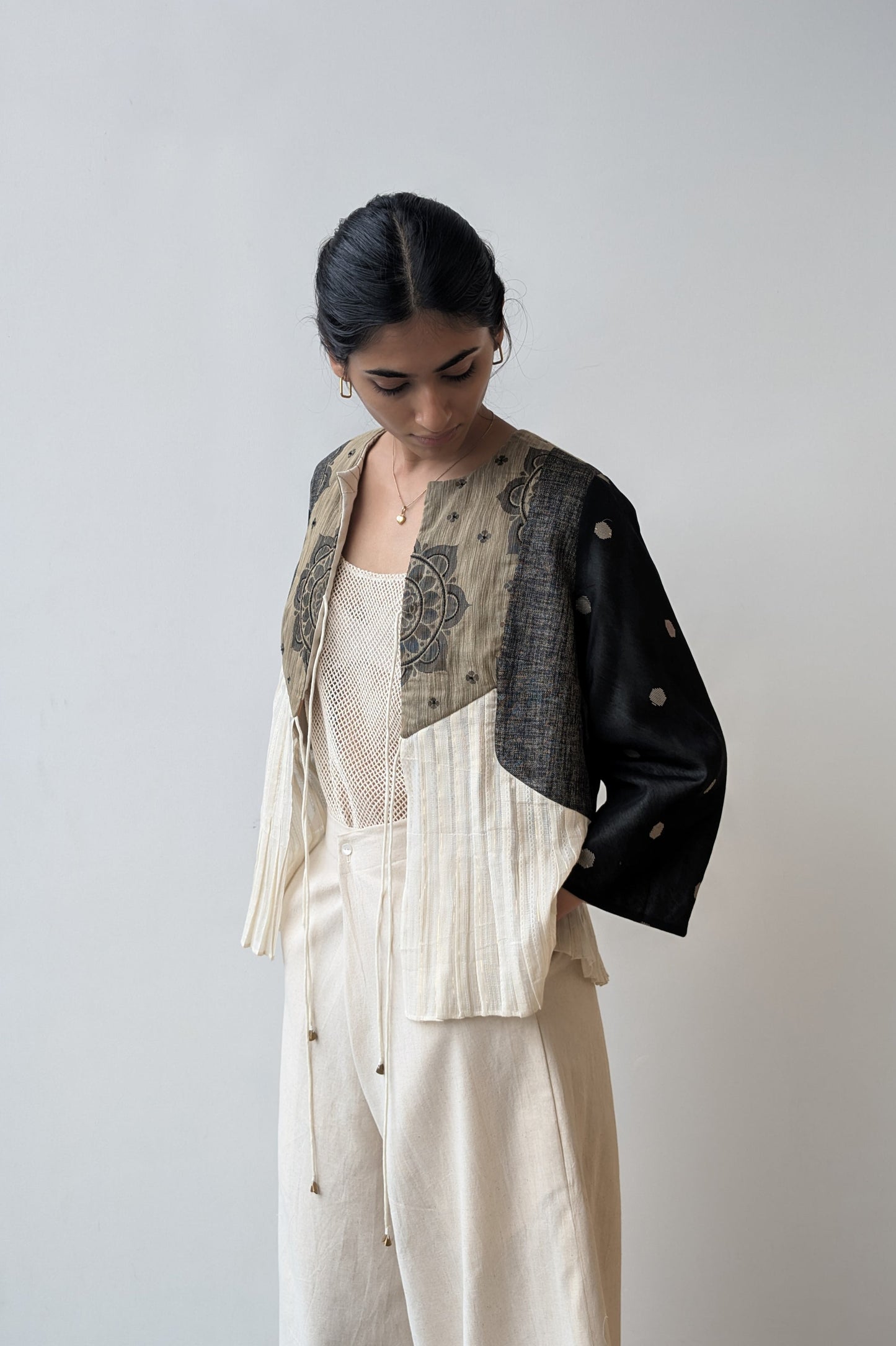Woman wearing a reversible layered outfit with a jacket, top, and pants against a plain background for Diwali & festive occasions.