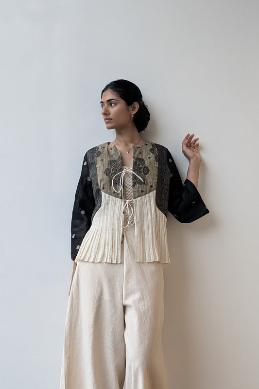 Woman wearing a upcycled, reversible black and white outfit against a plain background  for Diwali & festive occasions.
