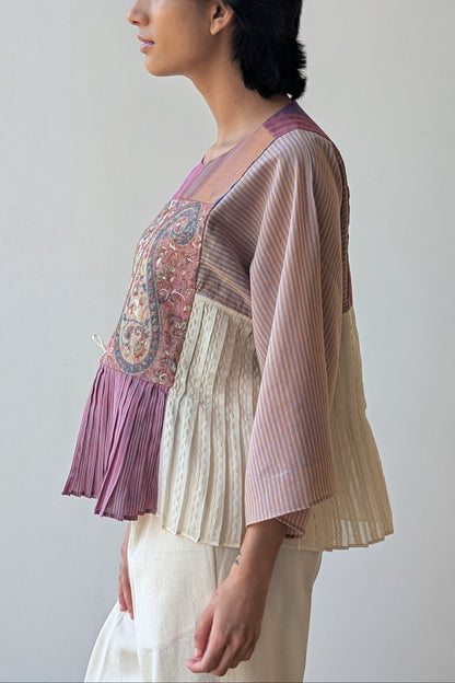 Woman wearing a reversible layered top and cardigan against a plain background  for Diwali & festive occasions.